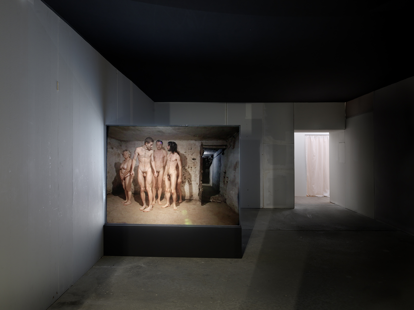 Artur Żmijewski „Kullimäng" (1999). Videoteos, kus grupp alasti inimesi mängib kunagi gaasikambrina kasutatud ruumis kulli. Foto: André Morin