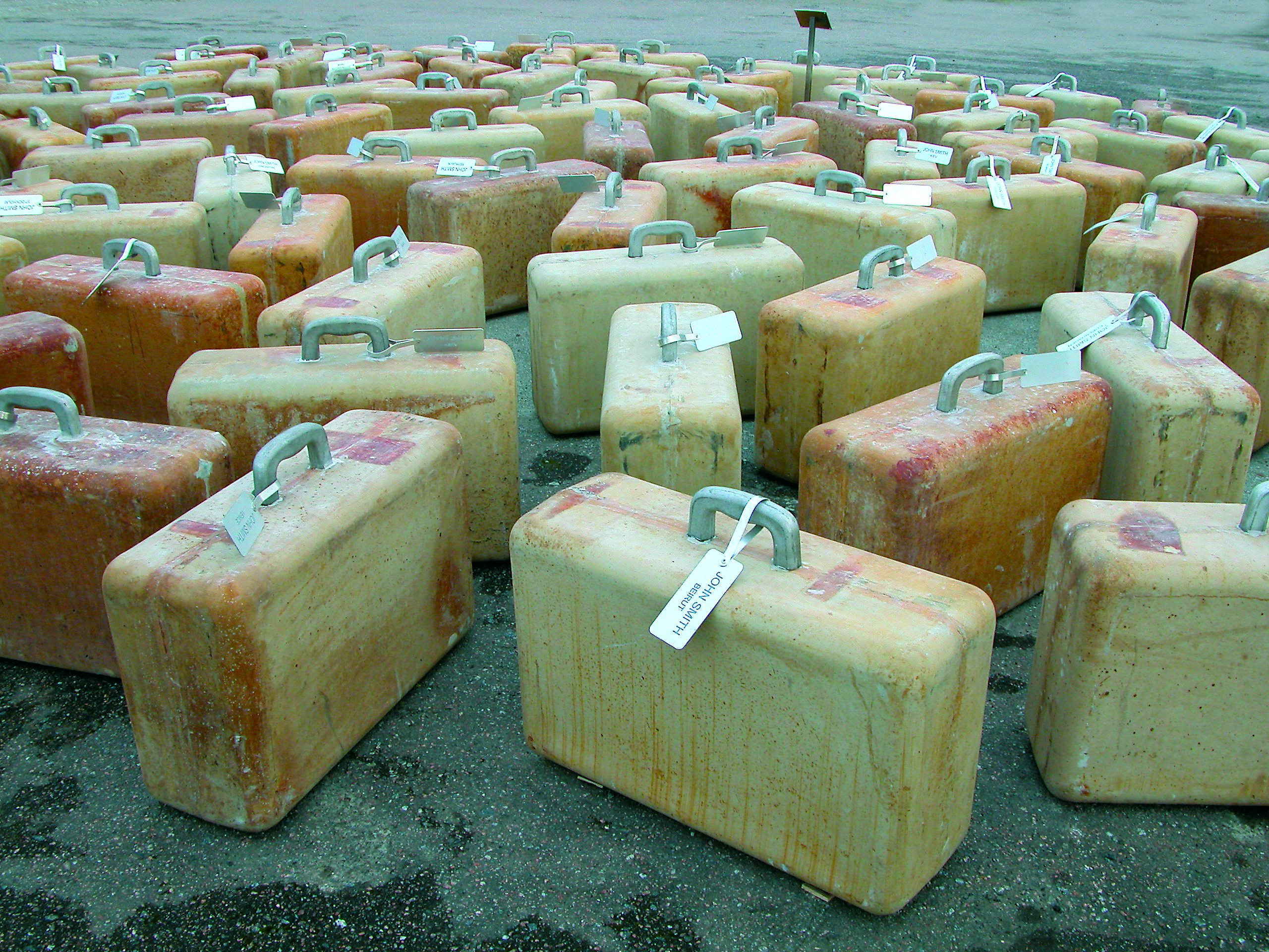 Marko Mäetamme ja Kaido Ole kunstiprojektis „100 John Smithi” valminud betoonist ja alumiiniumist kohvrid sümboliseerivad Okupatsioonide Muuseumi siseõues inimesi, keda sunniti küüditamise tõttu kodust lahkuma.